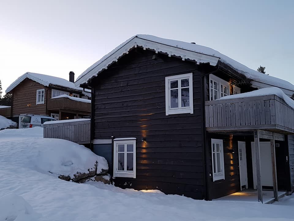 Mørk hytte i vinterlandskap